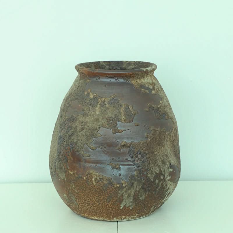 Handmade rounded irregular stoneware ceramic vase in earthy brown tones, Wabi Sabi style home decor.